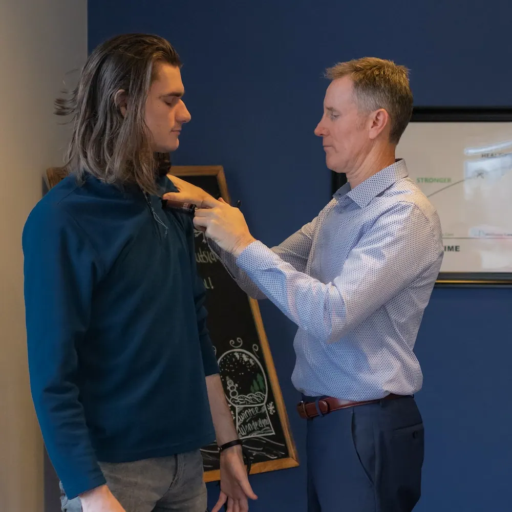 Dr. Craig Ellison assessing a patient's posture and shoulder alignment