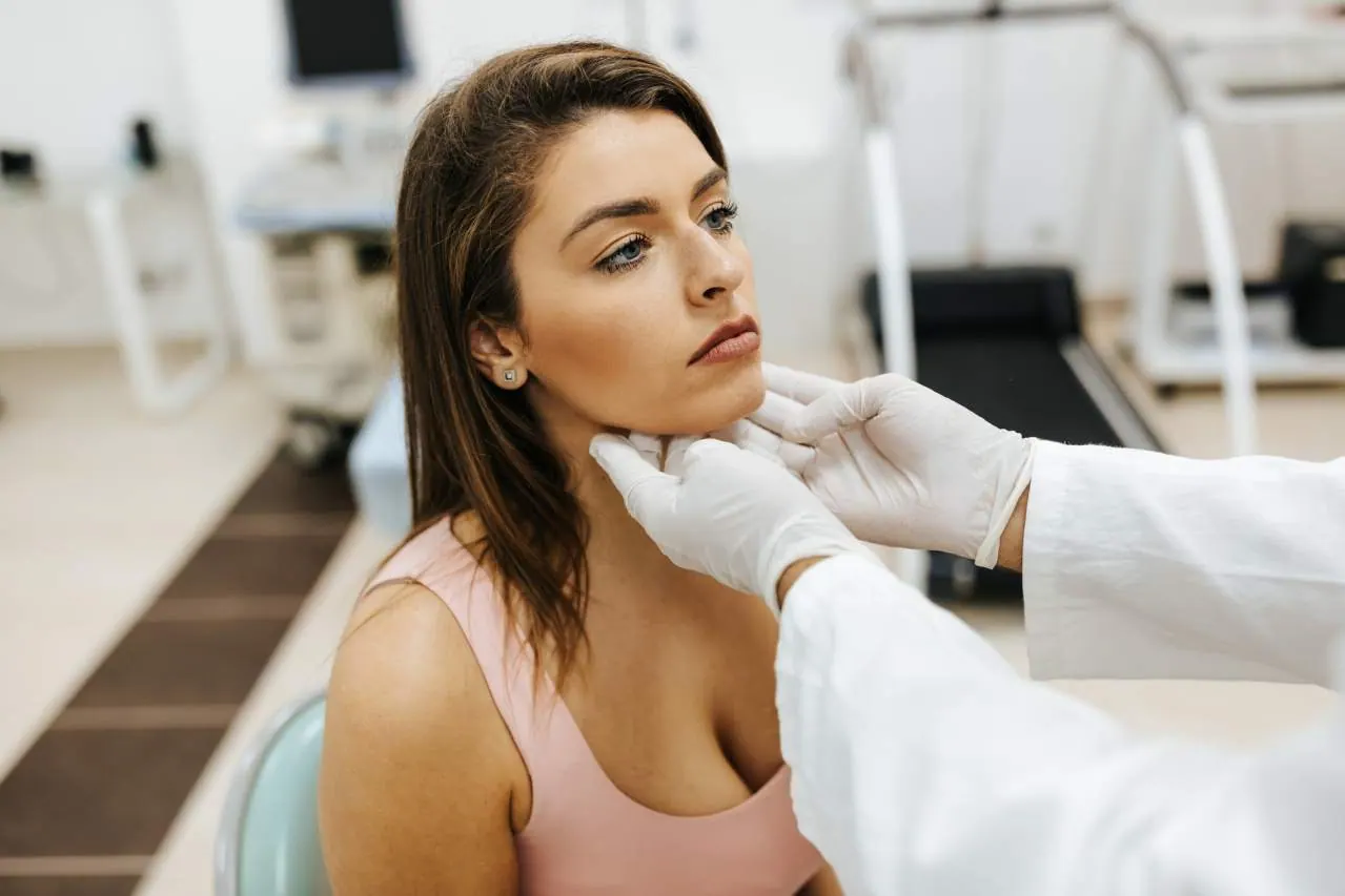 doctor checking woman thyroid condition
